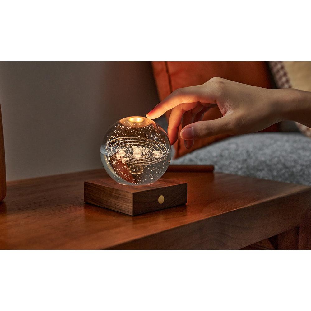 Gingko Design Amber Crystal Light - Solar System  with model's hand- Science Museum Shop
