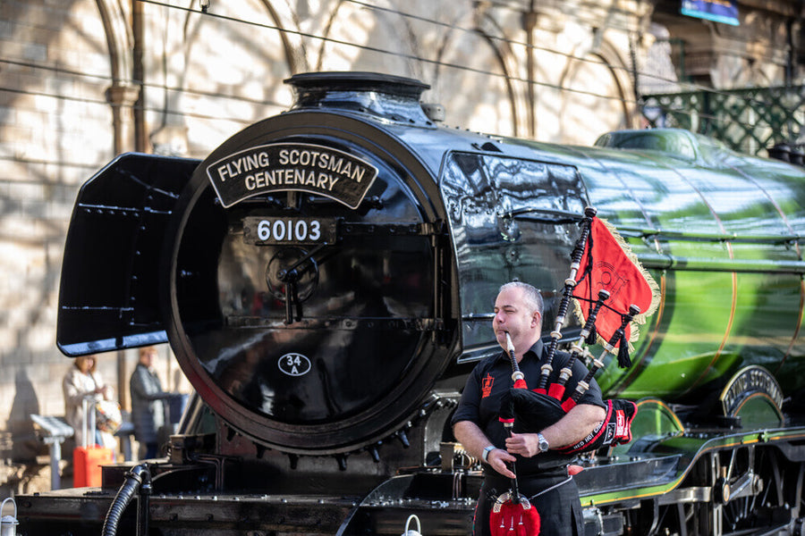 Kevin MacDonald from the Red Hot Chilli Pipers beside Flying Scotsman. Art Print - Science Museum Shop