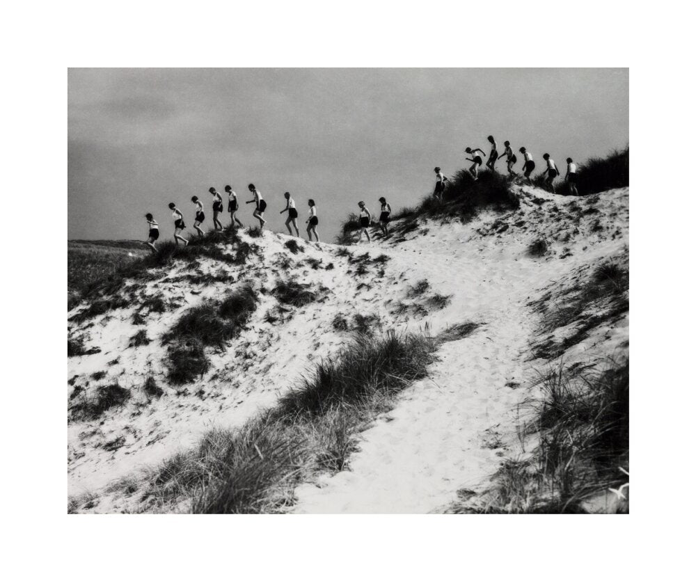 Horizon line of women walking over dunes, about 1930. unstretched canvas medium none Art Print - Science Museum Shop